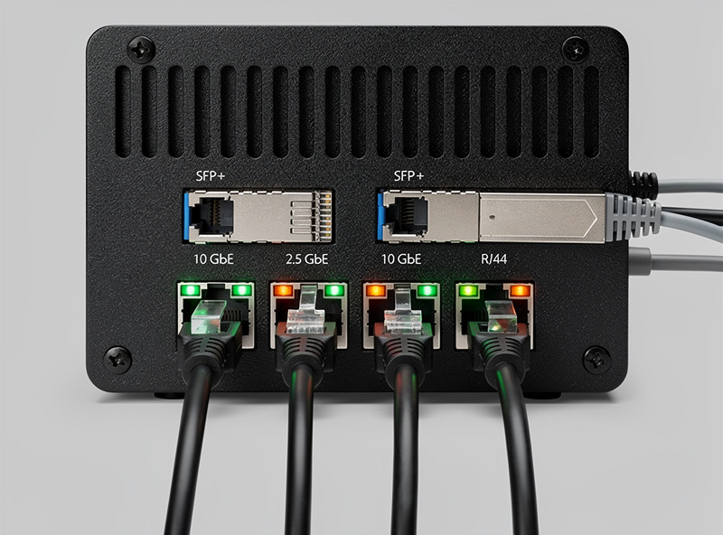 Protectli FW6E 10 GbE router mounted in a homelab rack with SFP plus modules connected and active status lights showing 10 gigabit operation