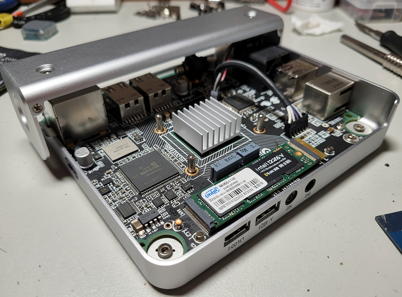 Internal view of a Topton N100 mini PC with the case open showing the Intel N100 CPU heatsink Intel NIC chips and NVMe SSD installed