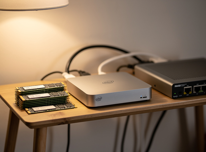 Low-power Intel mini PC running Proxmox on a small homelab shelf with NVMe storage and a managed network switch