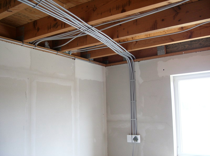 Network cables routed neatly through wall cavities and across ceiling joists during a structured wiring install